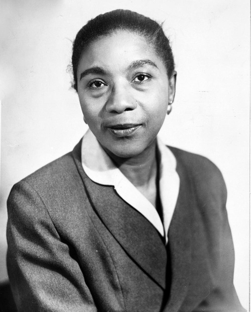 Black and white headshot of Maida Springer Kemp. Her hair is pulled back and she is wearing a white blouse and dark jacket.