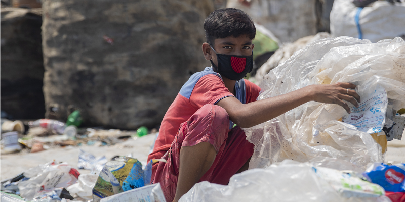 Miajul, age 12 and from Shyamol Palli in the capital city of Dhaka, sorts through hazardous plastic waste to support his family during the pandemic-related lockdown, without any protection.