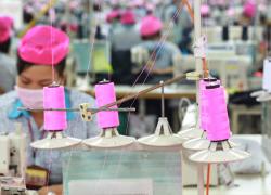 Una trabajadora de la confección en una fábrica de Better Work en Vietnam. Better Work está financiado por el Departamento de Trabajo de los Estados Unidos para mejorar las condiciones laborales en las cadenas mundiales de suministro textil y de la confección. Crédito: Better Work. 