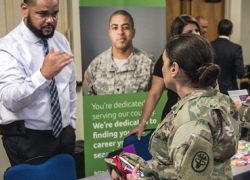 Photo from job fair of a civilian employer speaking with a service member