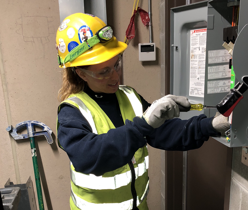 Katelyn addresses an electrical problem at work.