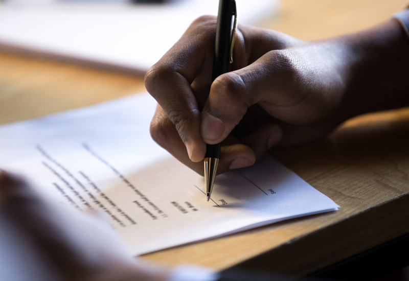 Close-up of a hand signing an employment contract.