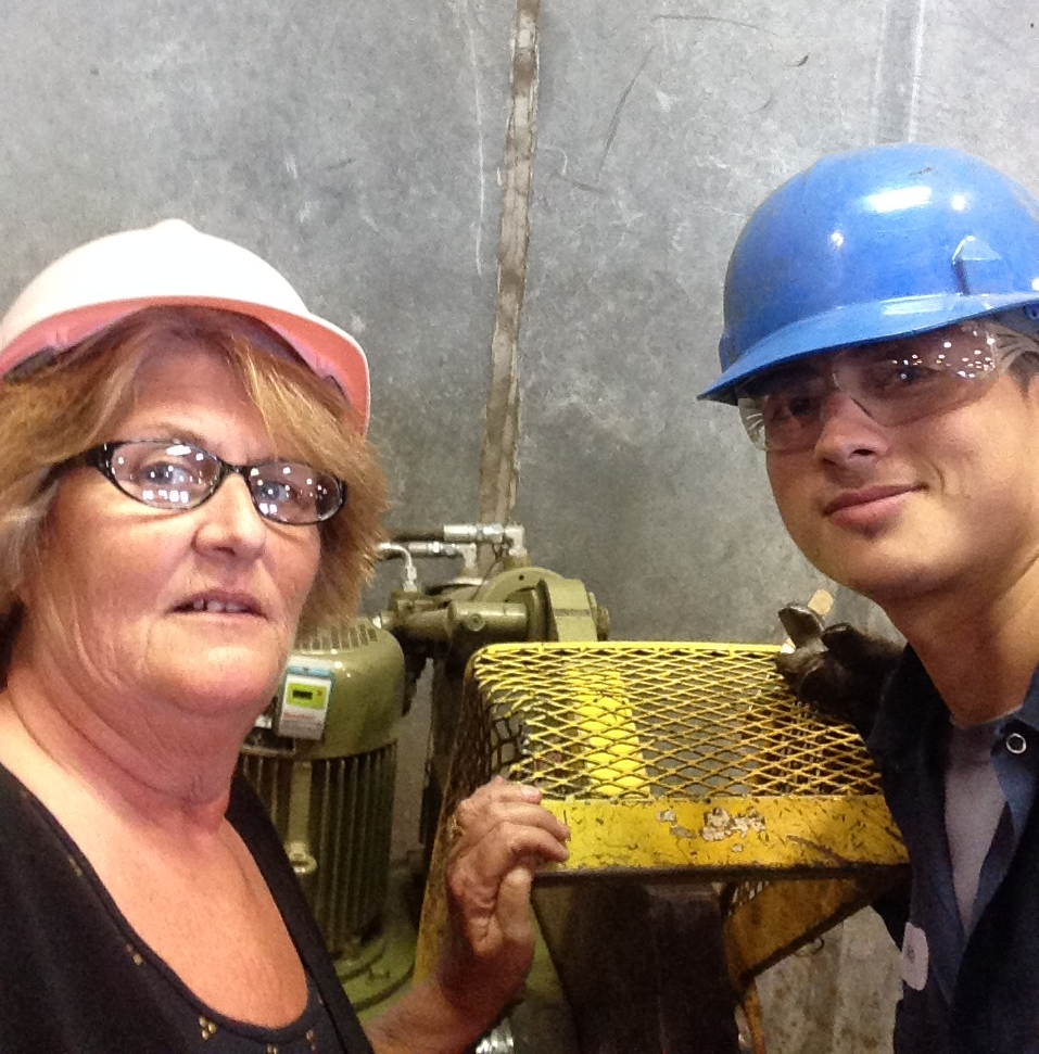 Lisa and employee Delfino Uteras discuss safety procedures for the copper cutter.