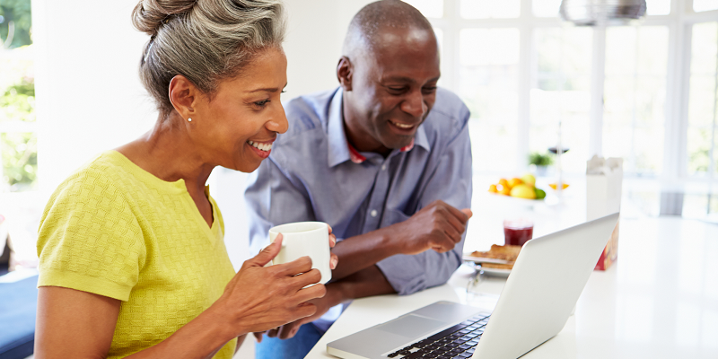 An older Black couple use a laptop for retirement planning