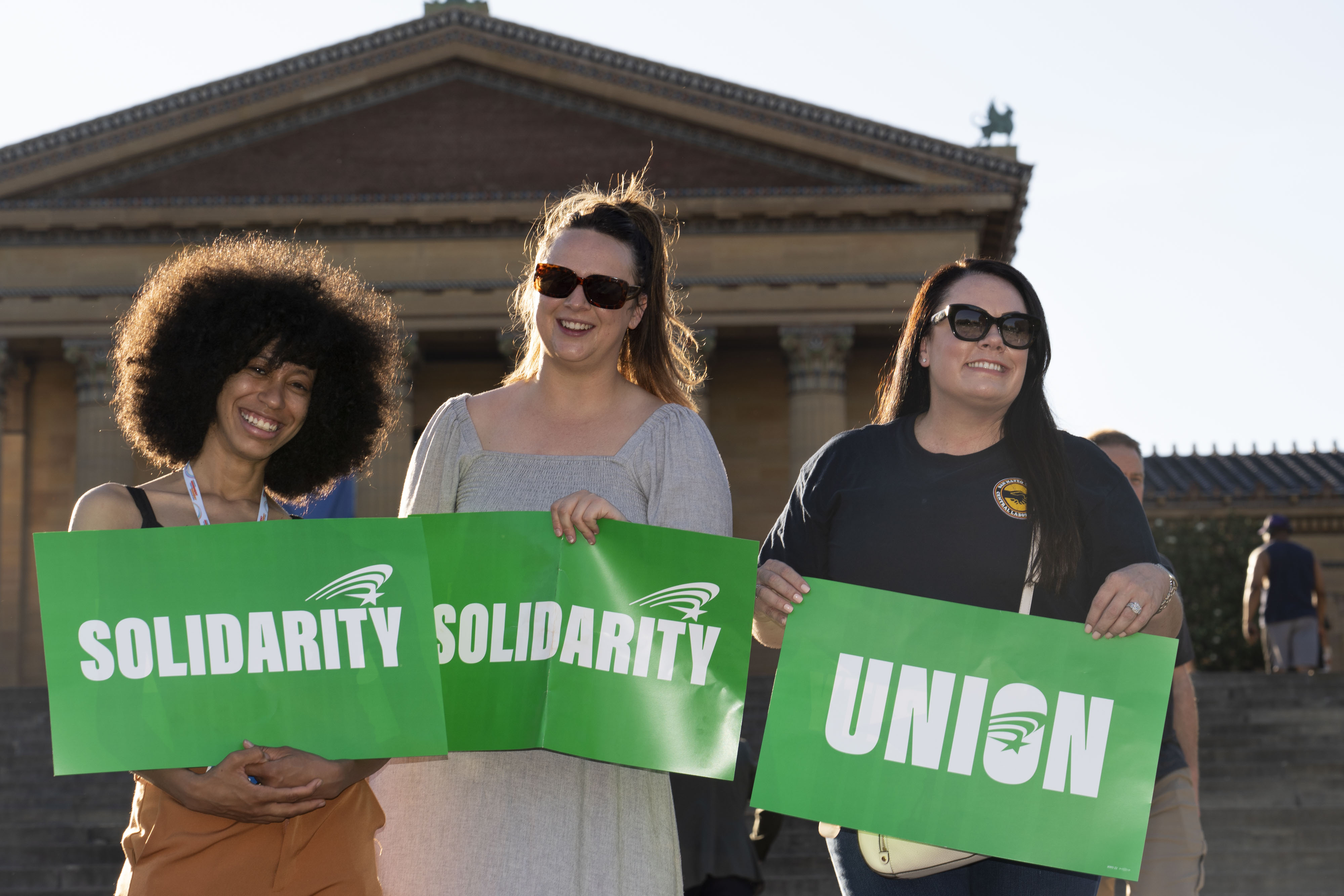 A photo of three women each holding a sign.