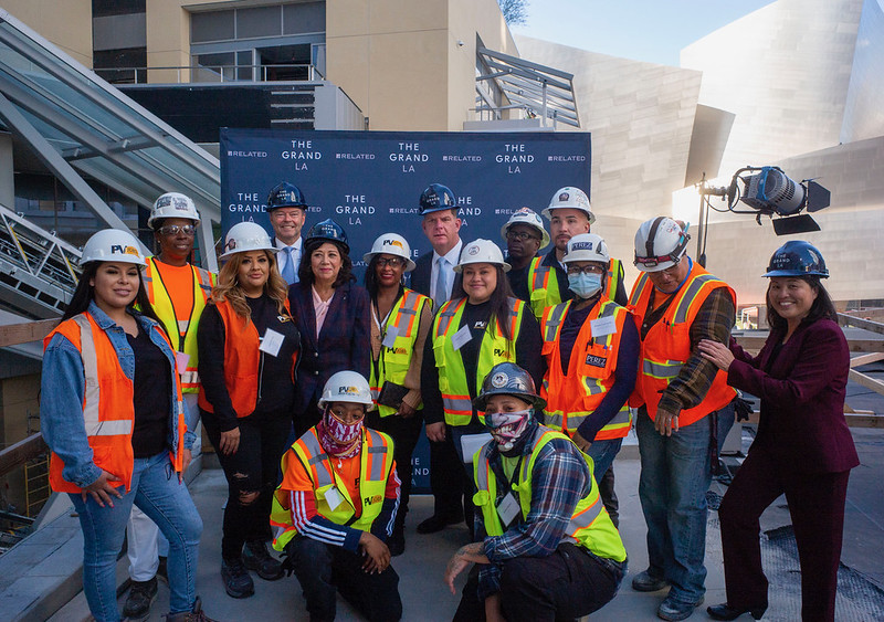 US Secretary of Labor Marty Walsh and Deputy Secretary Julie Su pose for a photo with construction workers and apprentices at the Grand Avenue Project in Los Angeles