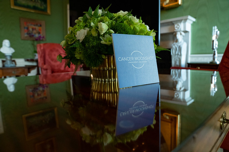 Cancer Moonshot logo on a light blue card on a brown table at the White House