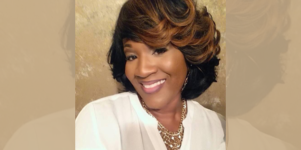 Headshot of a Black woman smiling at the camera.