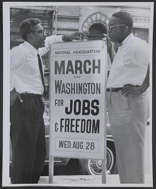 2.	Dos hombres negros junto a un cartel que dice “March on Washington For Jobs & Freedom” (Marcha en Washington por el trabajo y la libertad). Mier. 28 de agosto