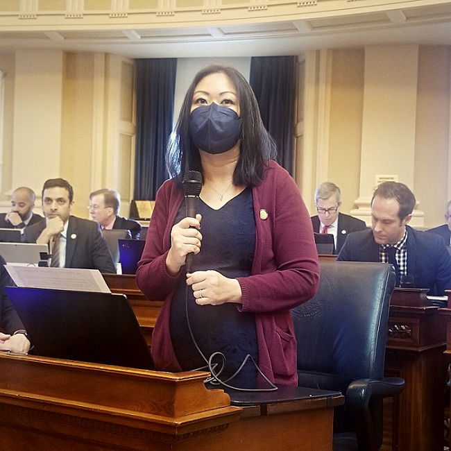 A photo of Kathy Tran with a microphone. 