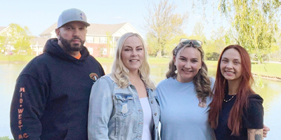 Raegan Ferguson stands outside with her husband and two daughters.