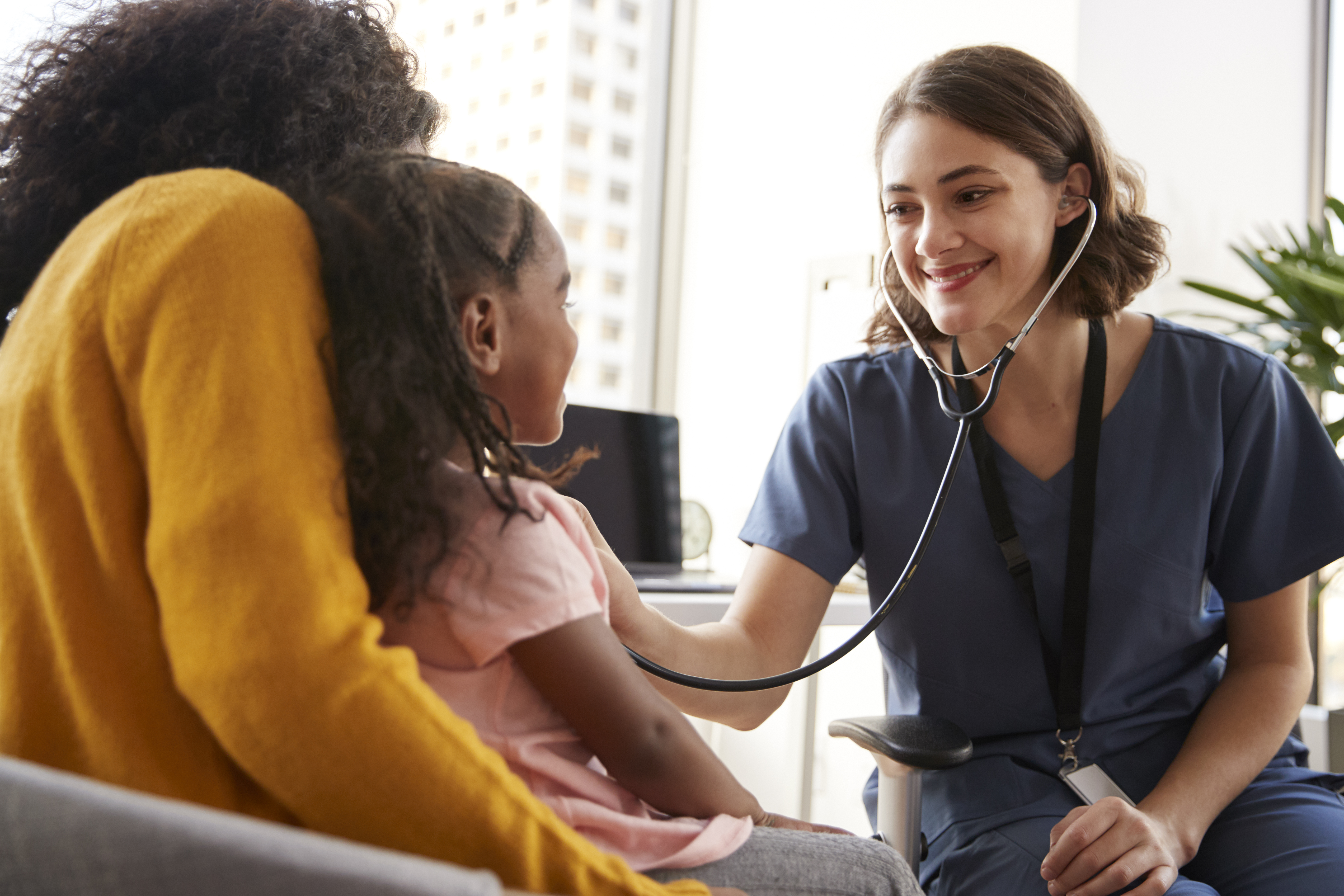 A healthcare provider sitting with a family