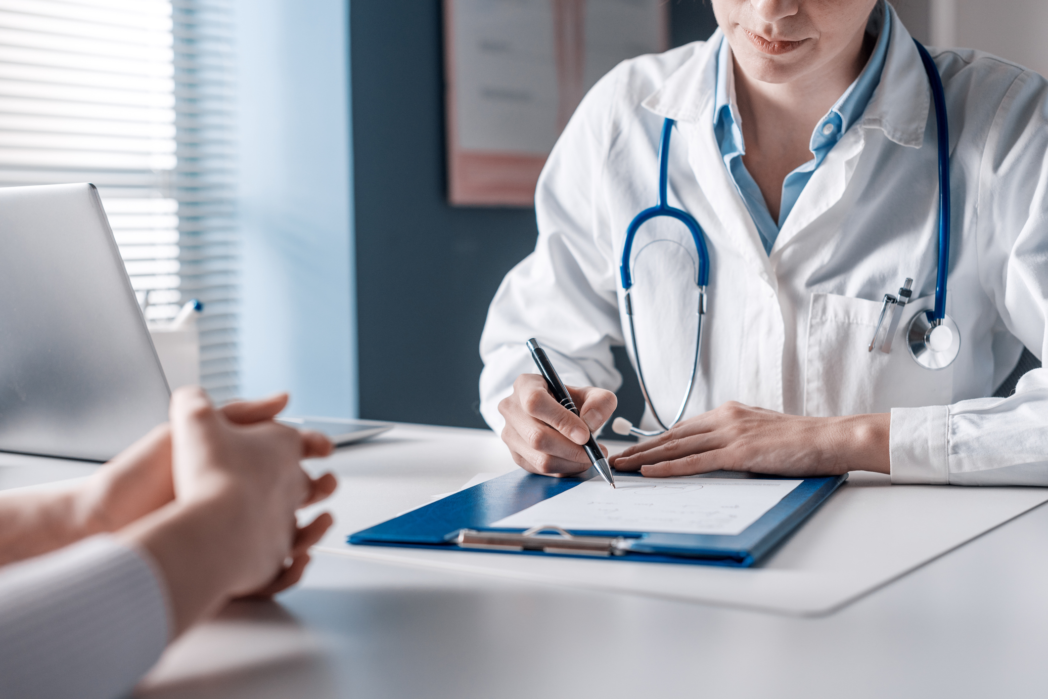 A doctor sits with a patient