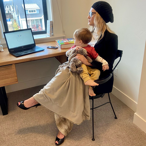 Nicole and her son sit at her desk