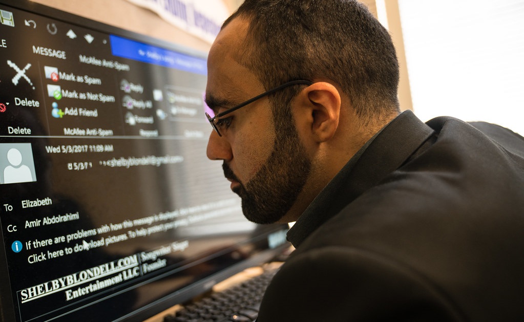 A male worker with a visual impairment uses a large computer screen.