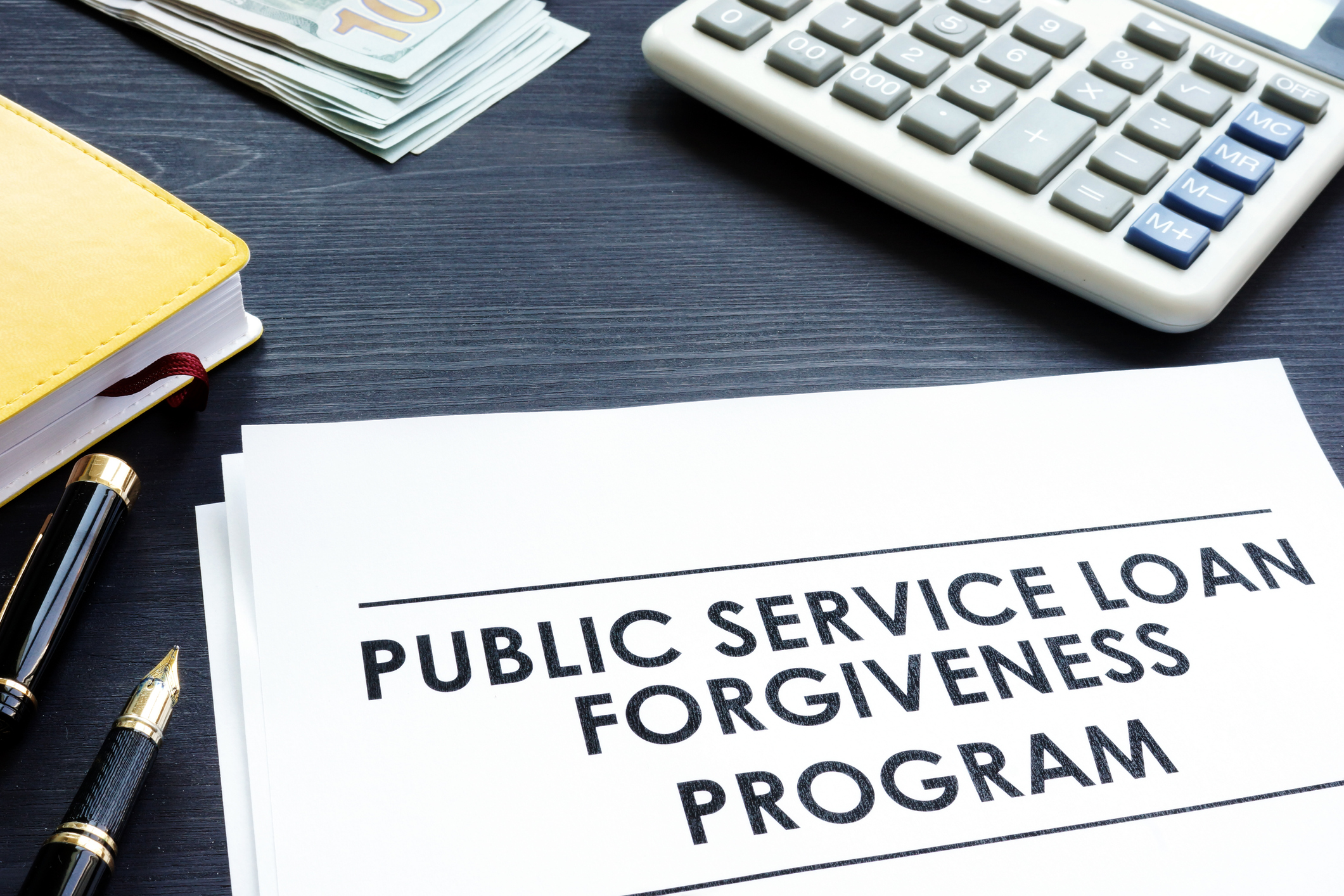 A page on a desk with the words Public Service Loan Forgiveness.