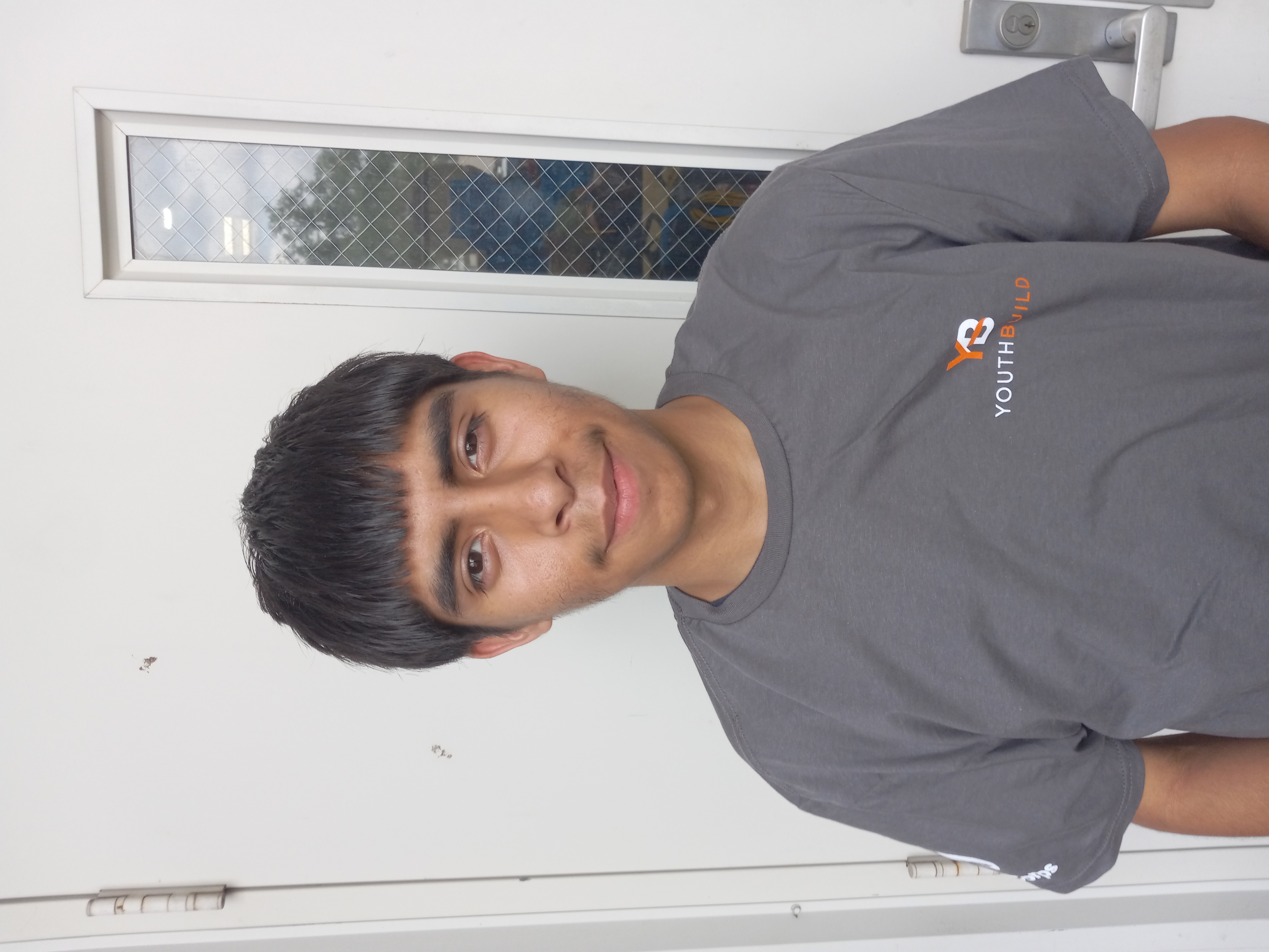 Robert Fabela wearing a gray YouthBuild t-shirt.