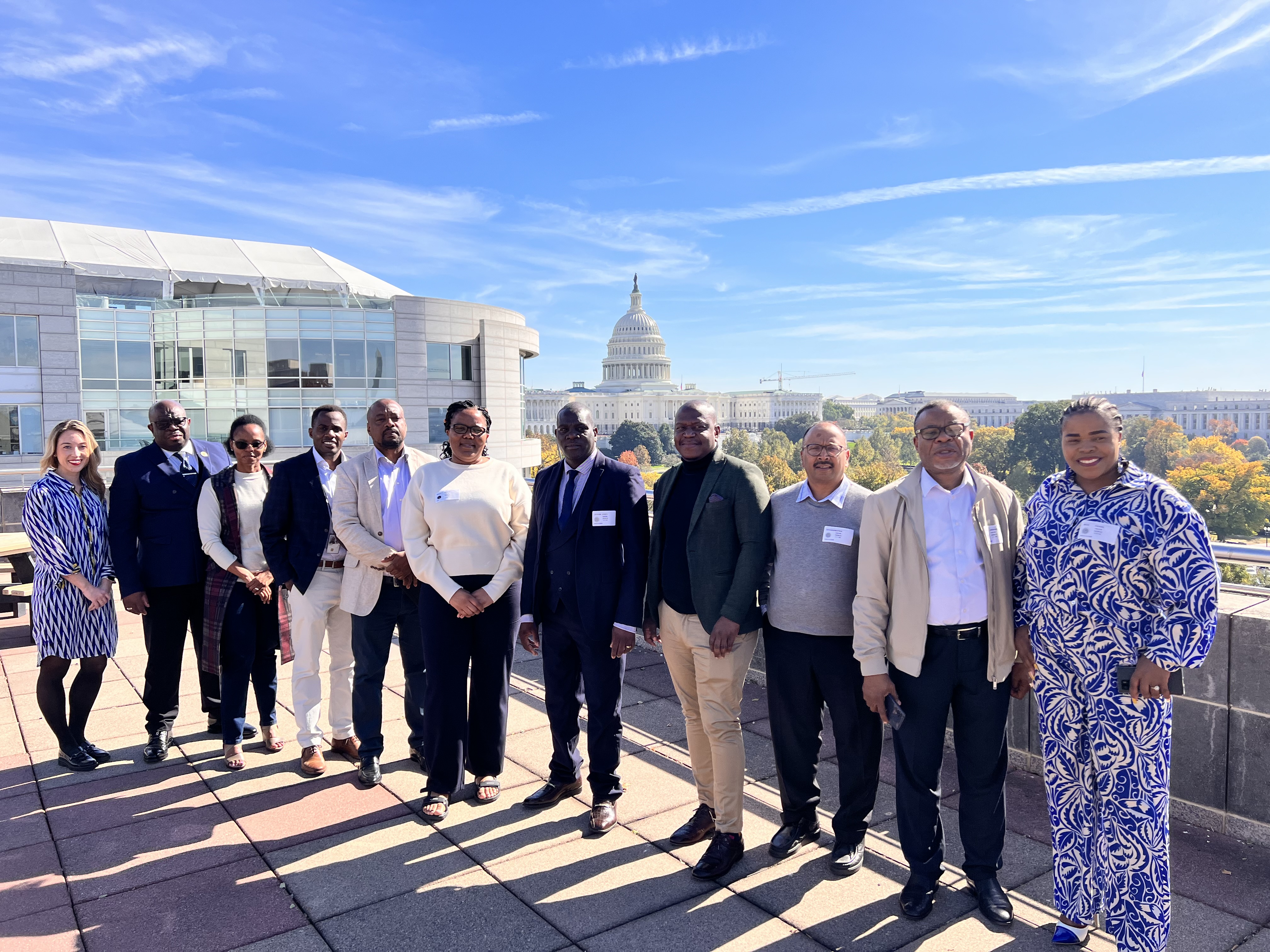 A group of 11 South African and U.S. officials posing on a rooftop overlooking the U.S. Capitol.