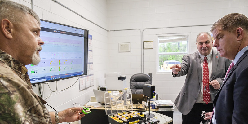 Jason Evans, Superintendent of Spanish Fort Water Systems, and Don Elswick, Director of SafeState at the University of Alabama, show safety equipment to Secretary of Labor Marty Walsh