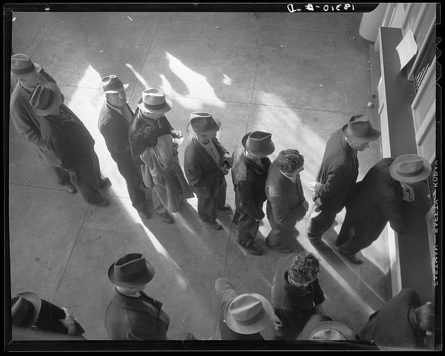 Line of men inside a division office of the State Employment Service office at San Francisco, California, waiting to register for benefits on one of the first days the office was open. 