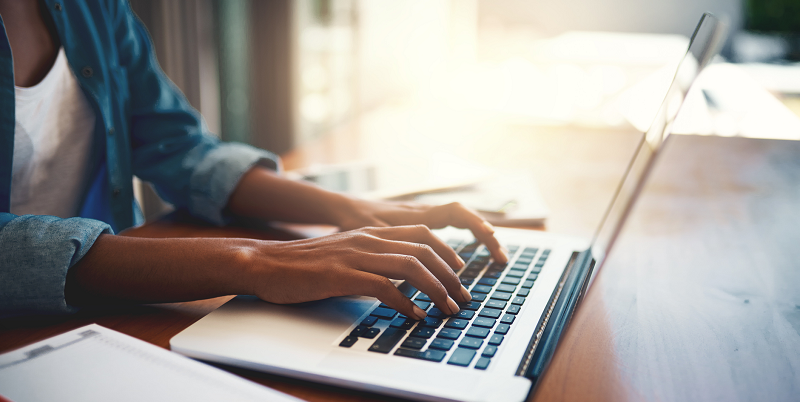 A Black woman uses a laptop