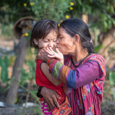A Nepali woman embraces a happy young child.