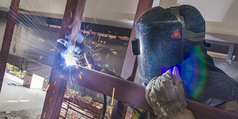 A worker in Mexico welds a metal joist.