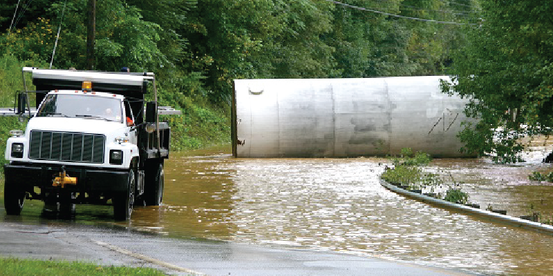 A white truck on a flooded roadway.