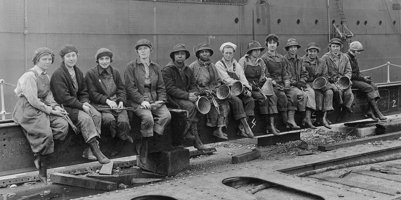 Women workers sitting on a steel beam in 1920