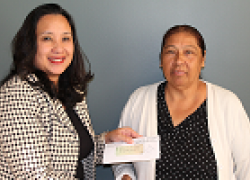 Bertha Gonzalez (right) receives a check for back wages from Kimchi Bui, district director for the Wage and Hour Division in Los Angeles.