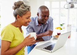An older black couple use their laptop for retirement planning