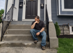 Diego Jimenez sitting on the front steps of a house.