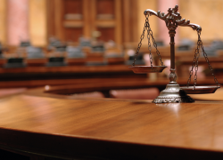 La balanza de la justicia sobre un escritorio en una sala del tribunal.