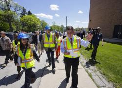 Secretary Marty Walsh walking in a yellow vest towards a construction site. 