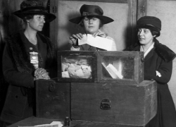 Three Wyoming women cast ballots in an undated black and white photo.