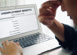 A man who looks discouraged fills out an online application for unemployment benefits