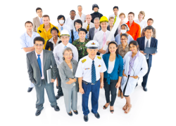 A group of white and blue collar professionals in various uniforms and business attire standing huddled together for a photo with a white background.