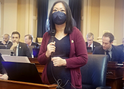 A photo of Kathy Tran with a microphone. 