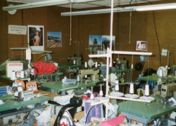 Photo of the sweatshop, with sewing machines and piles of fabric, where workers toiled in forced labor