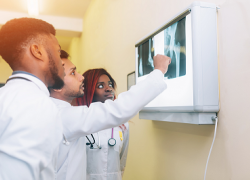 Three young medical apprentices review an X-ray