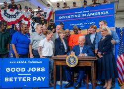 President Joe Biden, flanked by union members and labor leaders, signs an Executive Order to promote good jobs. Signs around him say "Investing in America" and "Good jobs, better pay." (Official White House Photo by Adam Schultz) 