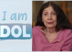 A woman with long brown hair and a pink shirt, with the text "I am DOL."