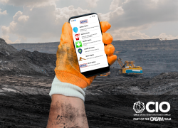 Wearing a work glove, a miner’s hand can be seen holding a mobile device and using the MSHA Safety + Health App.