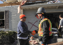 An OSHA inspector visits a home destroyed by a tornado to check on workers during cleanup and recovery efforts. 
