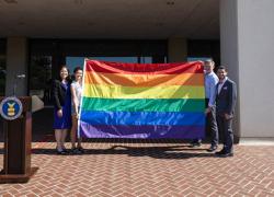 Deputy Secretary Julie Su standing with three individuals holding the PRIDE Flag. 