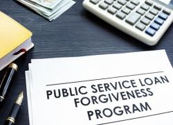 A page on a desk with the words Public Service Loan Forgiveness Program.