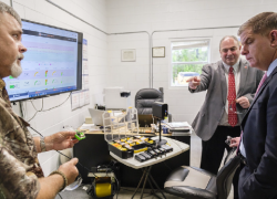 Jason Evans, Superintendent of Spanish Fort Water Systems, and Don Elswick, Director of SafeState at the University of Alabama, show safety equipment to Secretary of Labor Marty Walsh