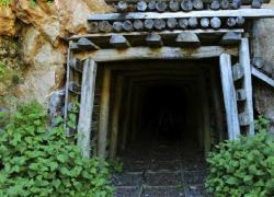 An entrance to an abandoned mine in the side of a rock formation. The tunnel leads to an underground coal mine.