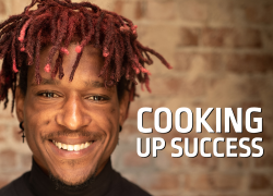 Headshot of STRIVE graduate, Jacob, in a black chef jacket with white text reading: Cooking up Success