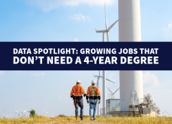 Two workers wearing fall protection gear walk toward large wind turbines in a field. "Data spotlight: Growing Jobs That Don’t Need a 4-Year Degree"